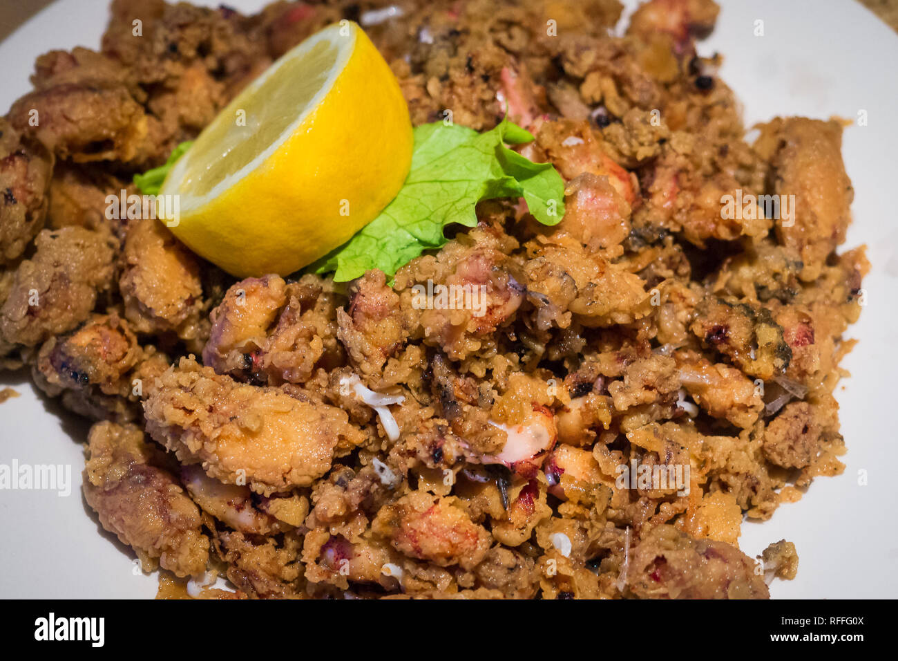 Platte von Chopitos, Platte kleiner Tintenfisch gebraten mit Zitrone, traditionelles Gericht Stockfoto