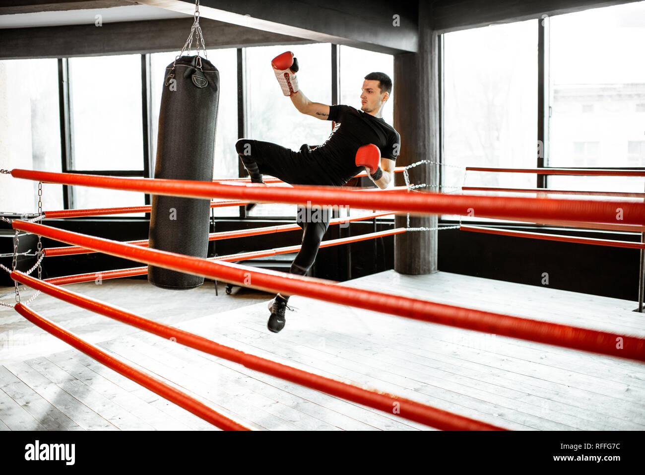 Athletischer Mann kicking Boxsack mit Bein, training Kickboxen im Boxring  an der Turnhalle Stockfotografie - Alamy