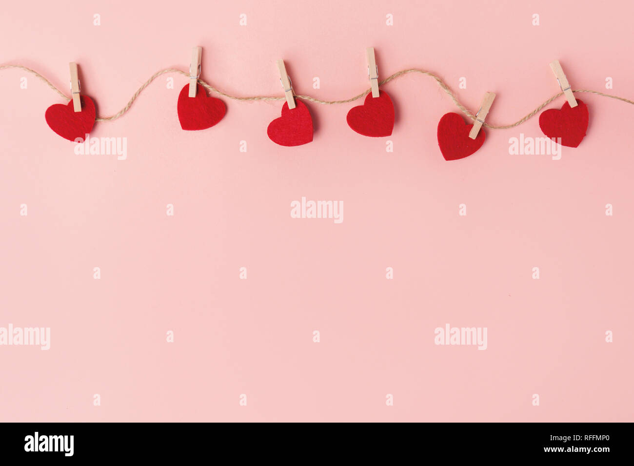 Schönen Valentinstag Herzen hängen am Seil auf rosa Hintergrund. Valentines Tag Konzept. Stockfoto