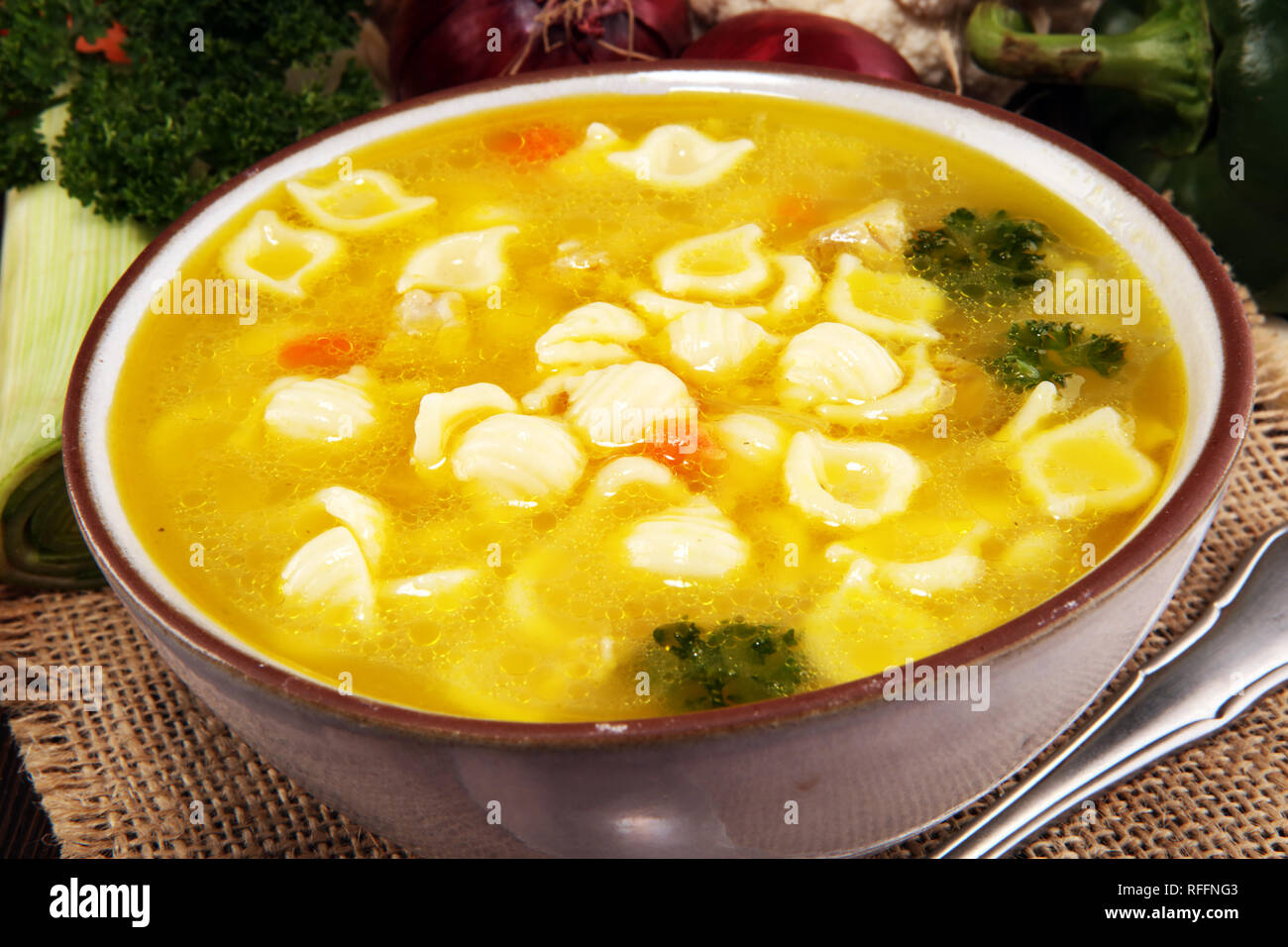 Klare Suppe mit Hähnchen und Nudeln. Brühe mit Karotten, Zwiebeln ...
