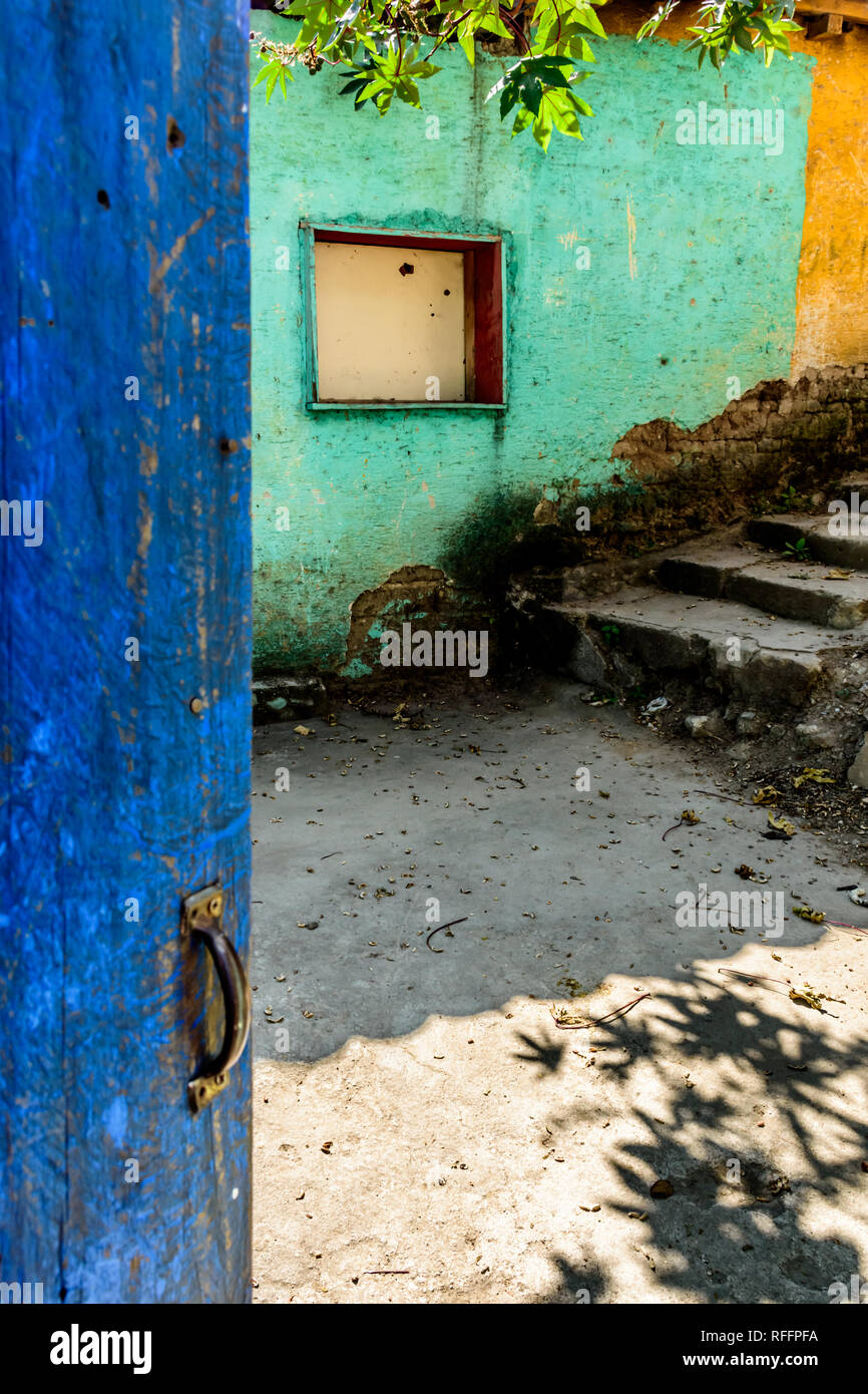 Öffnen Sie im Landhausstil blau lackierte Tür & Türkis & gelbes Gebäude Wand mit Verbrettert Fenster in Guatemala, Mittelamerika Stockfoto