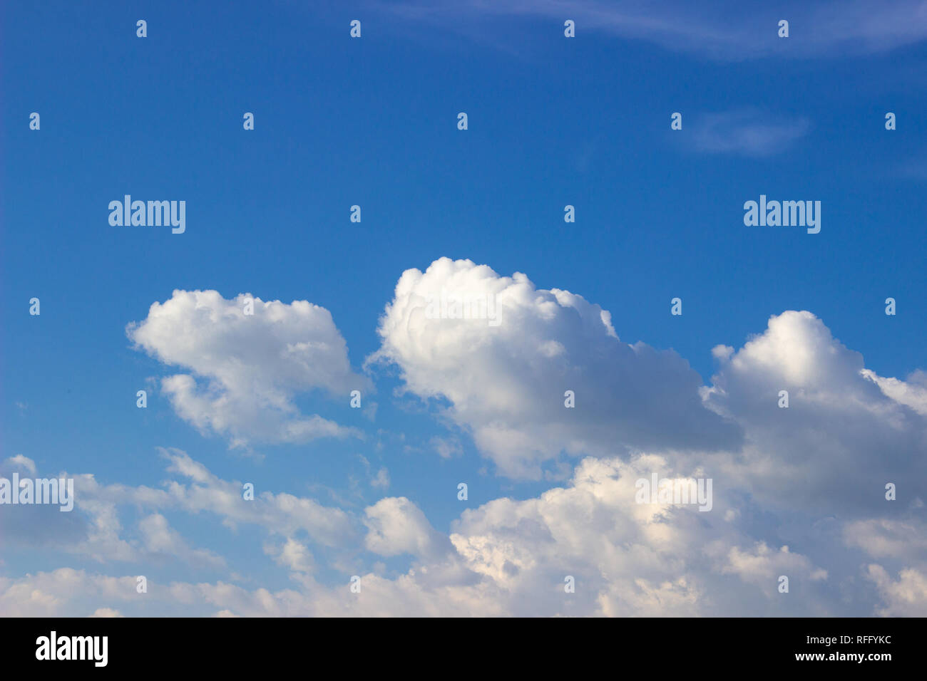 Dicke, flauschige weiße Wolken am blauen Himmel mit Kopierraum darüber. Stockfoto