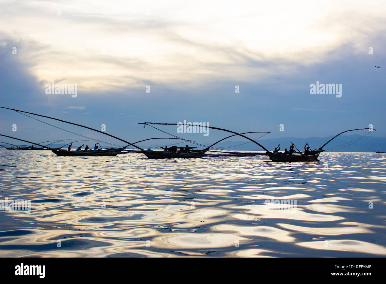 Traditionelle Fischerboote am Kivusee mit Reflexion der Sonne auf dem Wasser. Ruanda, Ost Afrika. Stockfoto