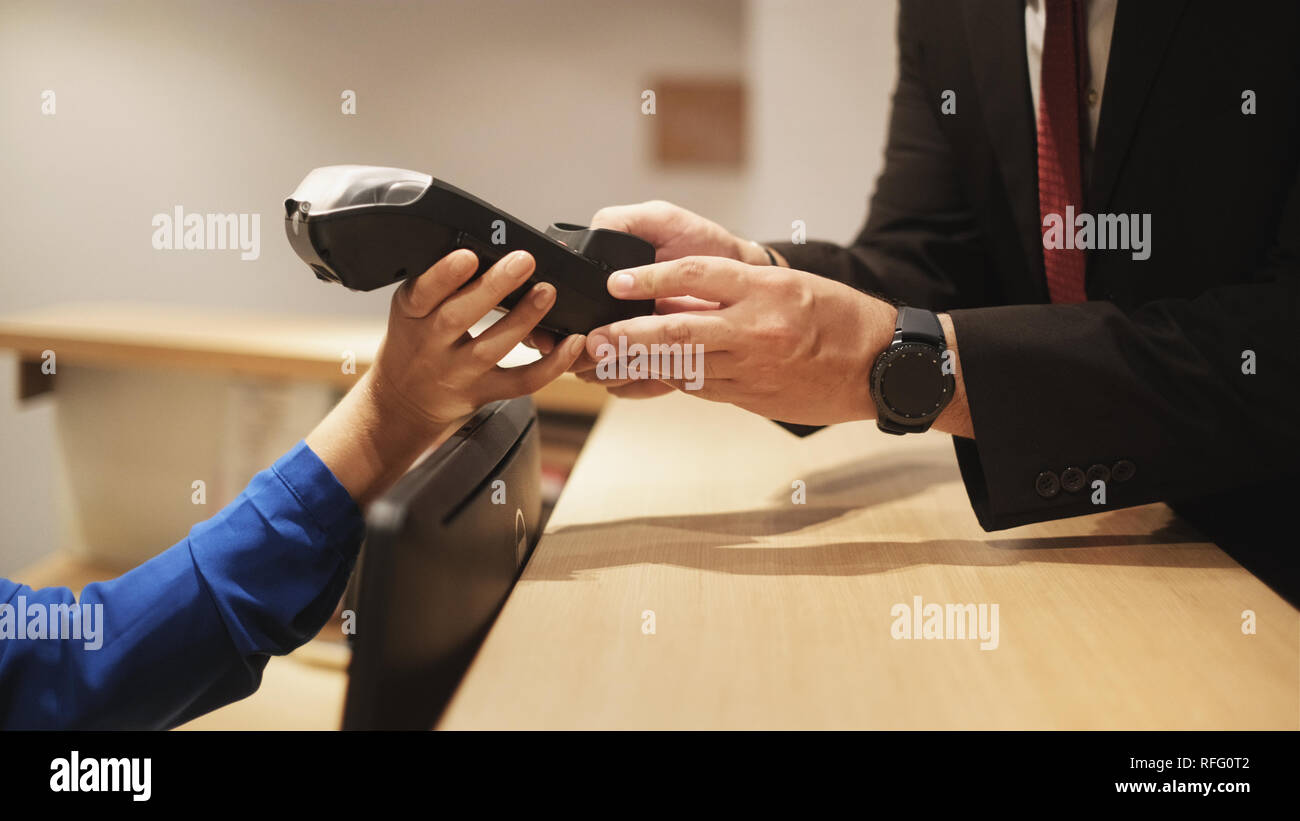 Hotelgäste zahlen Geschäftsreisen mit Kreditkarte und POS Stockfoto