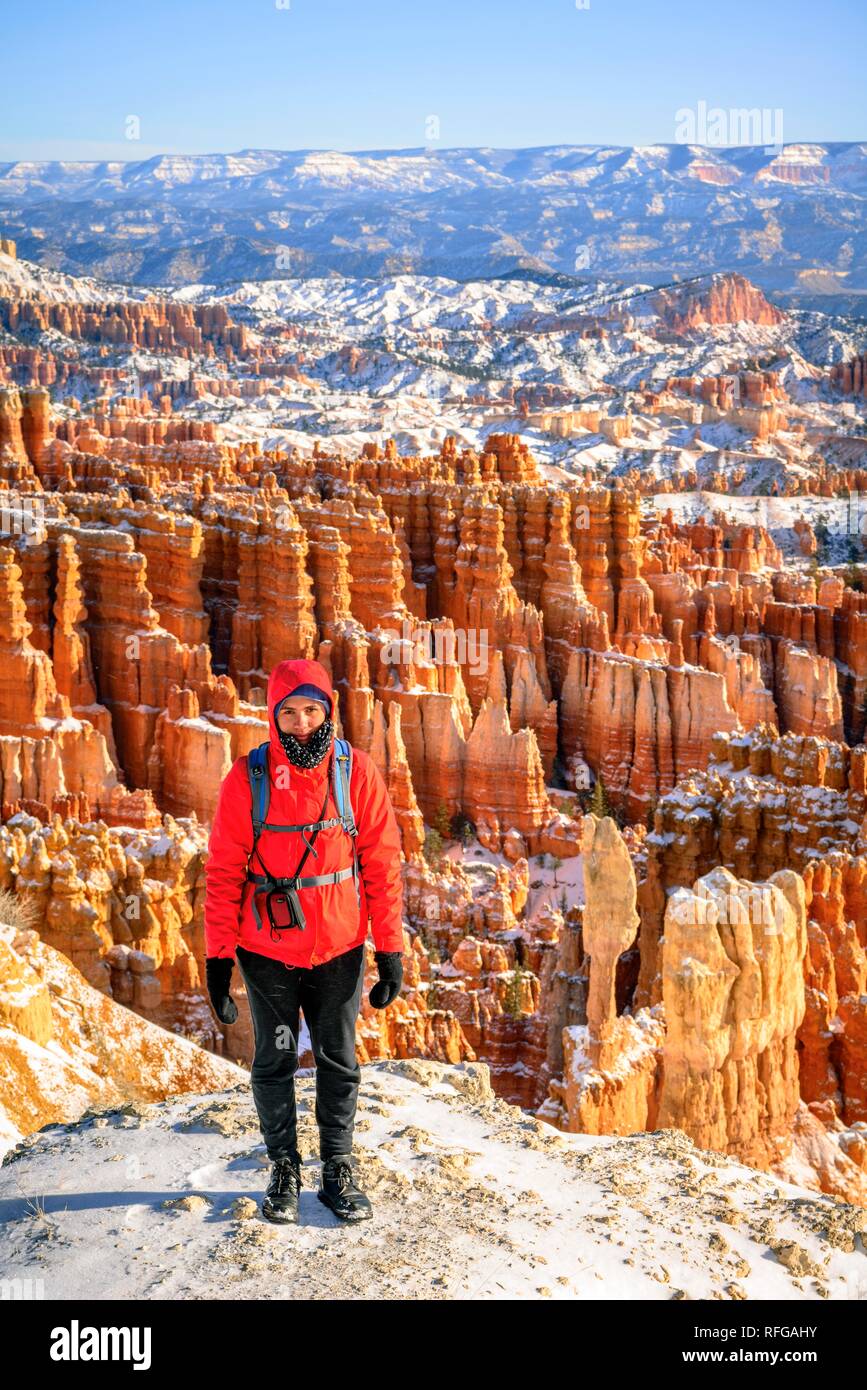 Junge Frau stand vor der Amphitheater, Morgenlicht, bizarr verschneite felsige Landschaft mit Hoodoos im Winter, Rim Trail Stockfoto