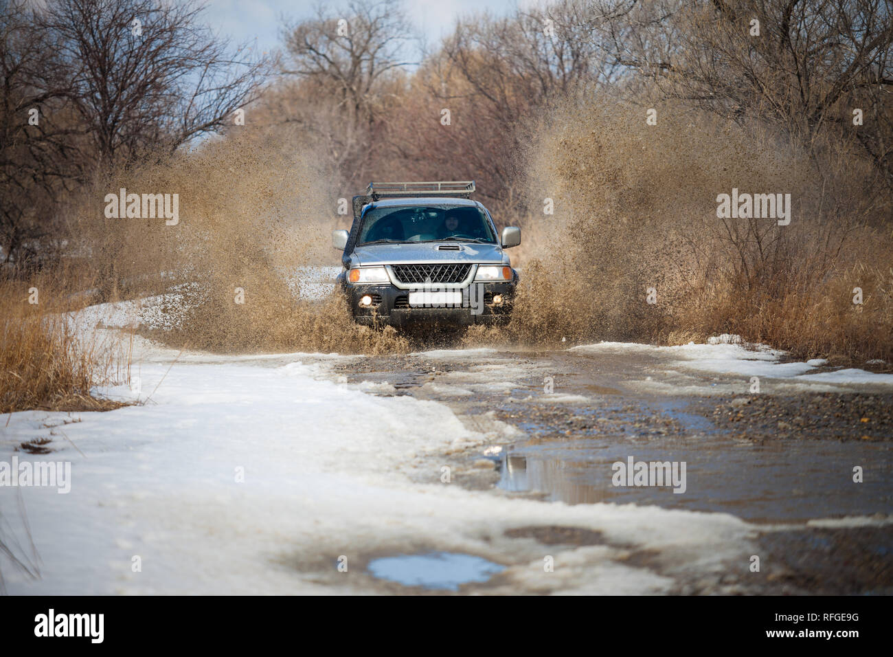 Chabarowsk, Russland - 25. MÄRZ 2017: Mitsubishi Pajero Sport auf unbefestigte Straße im frühen Frühjahr Spritzer, die von einer Pfütze Stockfoto