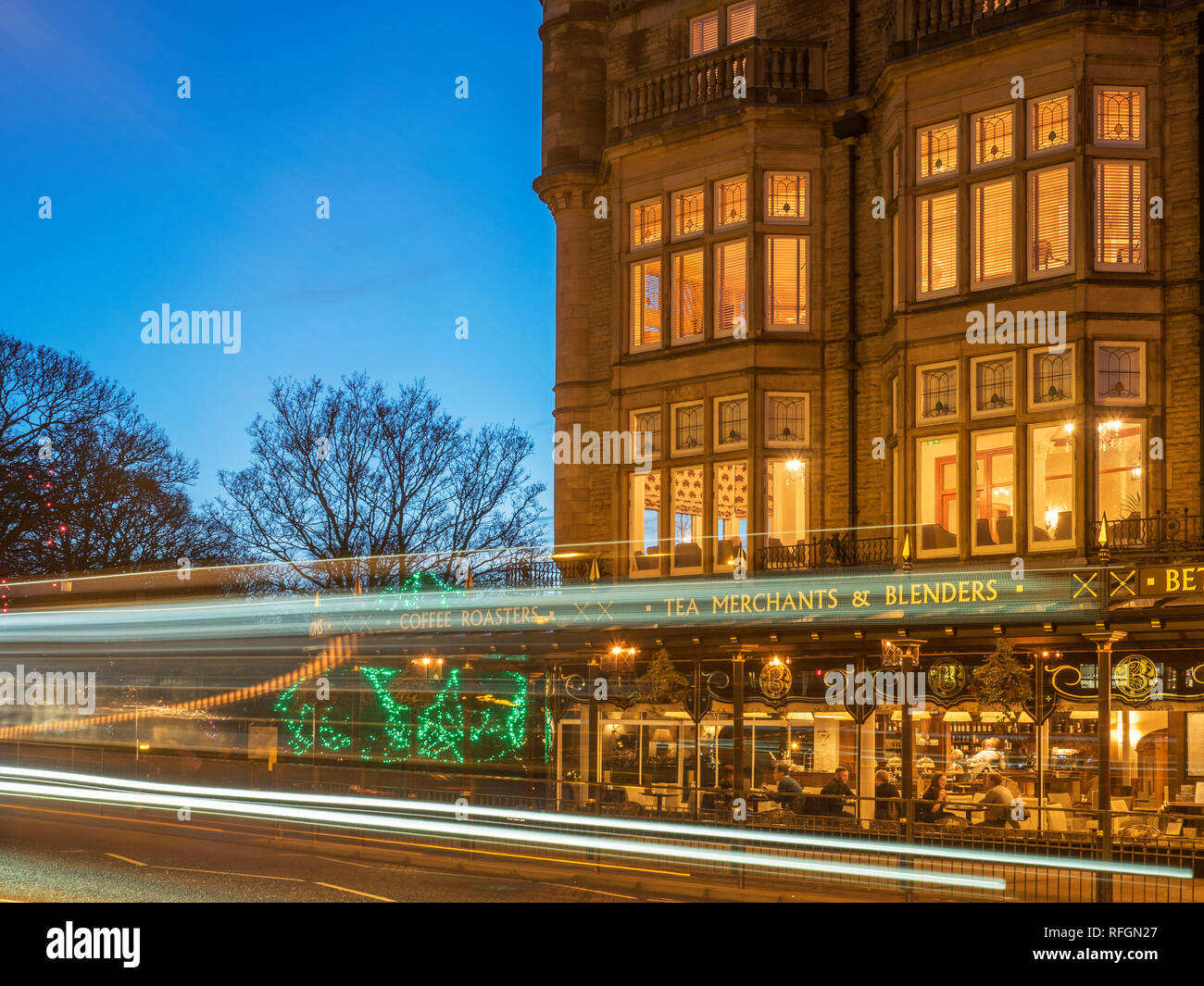 Verkehr Wege vorbei an Bettys Tea Rooms in der Dämmerung aus dem Parlament Straße Harrogate, North Yorkshire England Stockfoto