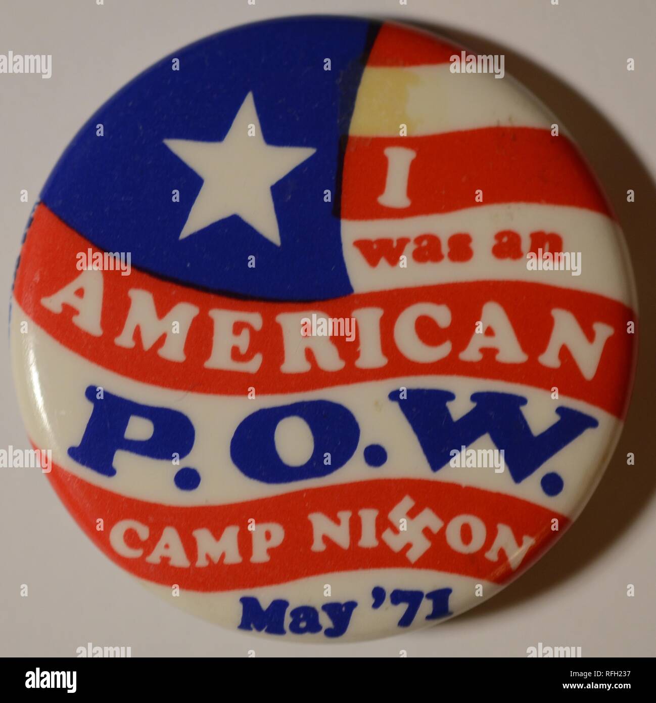 Rot, Weiß und Blau, anti-Krieg, Pin-zurück-Button oder Abzeichen, mit einem stilisierten, Amerikanische Flagge im Hintergrund, und der Text "ich einen Amerikanischen POW, Camp Nixon, Mai '71", wurde mit dem "X" in "Nixon" ersetzt durch ein Hakenkreuz, in Bezug auf die Inhaftierung von Tausenden von Demonstranten in Robert F Kennedy Stadion (das war schnell unter dem Namen "Camp Nixon") und anderen Washington DC Schauplätze, während der Demonstrationen am 1. Mai, während des Vietnamkriegs, Mai, 1971 hergestellt. () Stockfoto