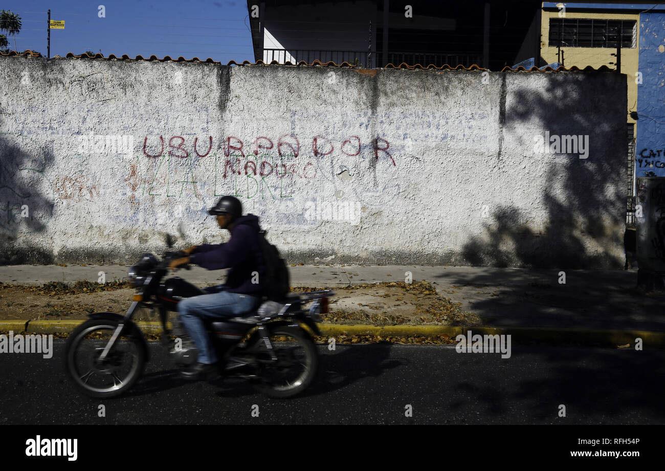 Valencia, Carabobo, Venezuela. Januar 25, 2019. 25 Jan, 2019. Die Bewohner vor einer Wand mit Graffiti gegen die Ablehnung von Nicolas Maduro, das Wort ''Maduro Usurpator'' auf verschiedenen Wände in verschiedenen Städten des Landes gelesen wird, die Fotos in der Stadt Valencia, Carabobo Zustand und entsprechen. Foto: Juan Carlos Hernandez Credit: Juan Carlos Hernandez/ZUMA Draht/Alamy leben Nachrichten Stockfoto
