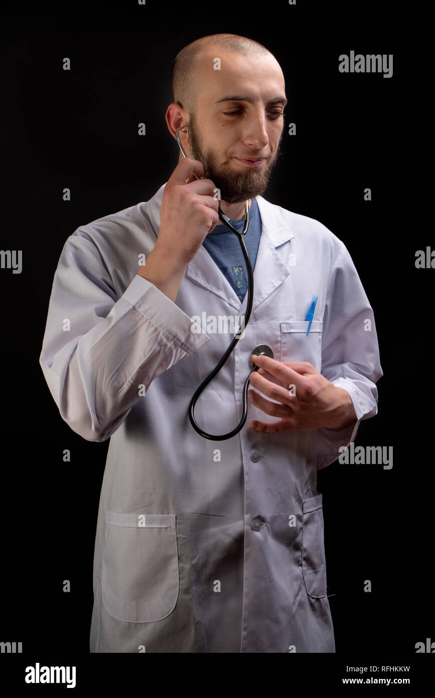 Männlicher Arzt mittels Stethoskop auf sich. Verrückten Spaß männlichen Praktizierenden über die Bedeutung der Gesundheit beachten Stockfoto
