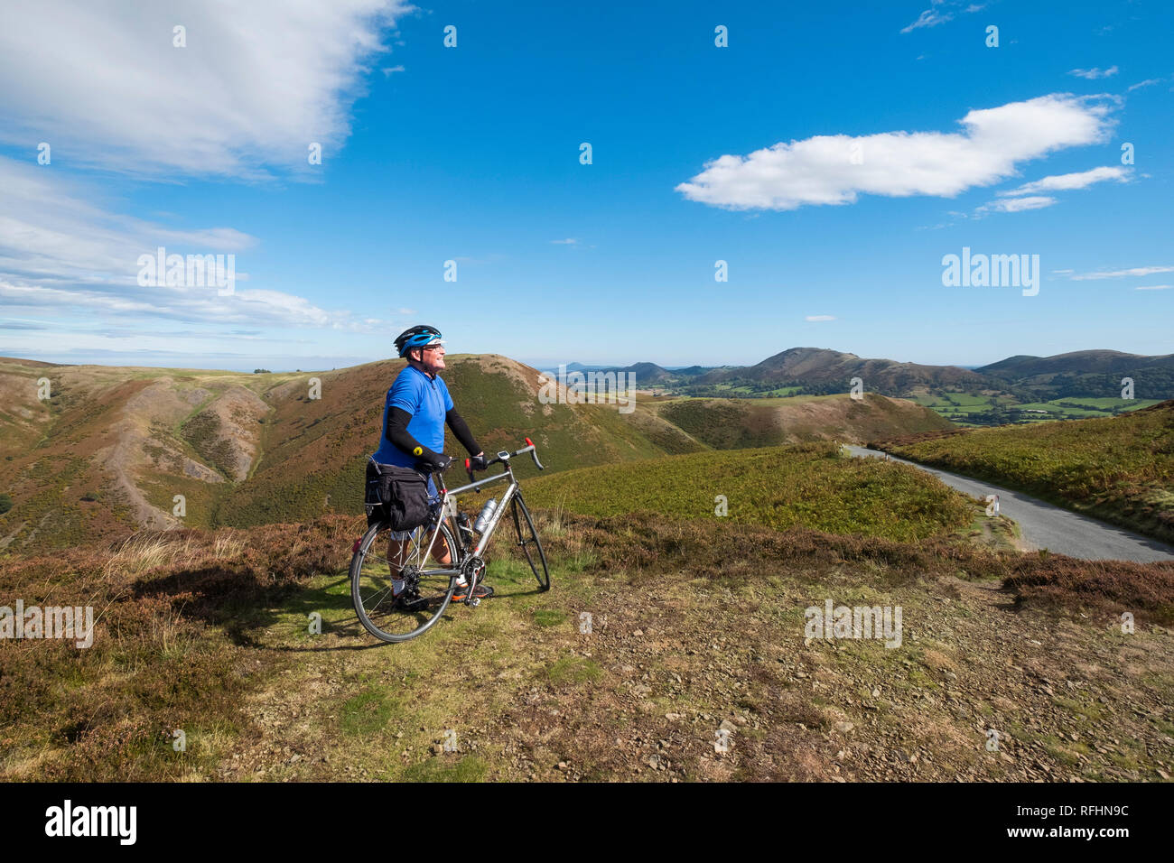 Eine männliche Radfahrer blickt auf den Shropshire Hills auf der Long Mynd in Church Stretton, Shropshire, England, Großbritannien Stockfoto