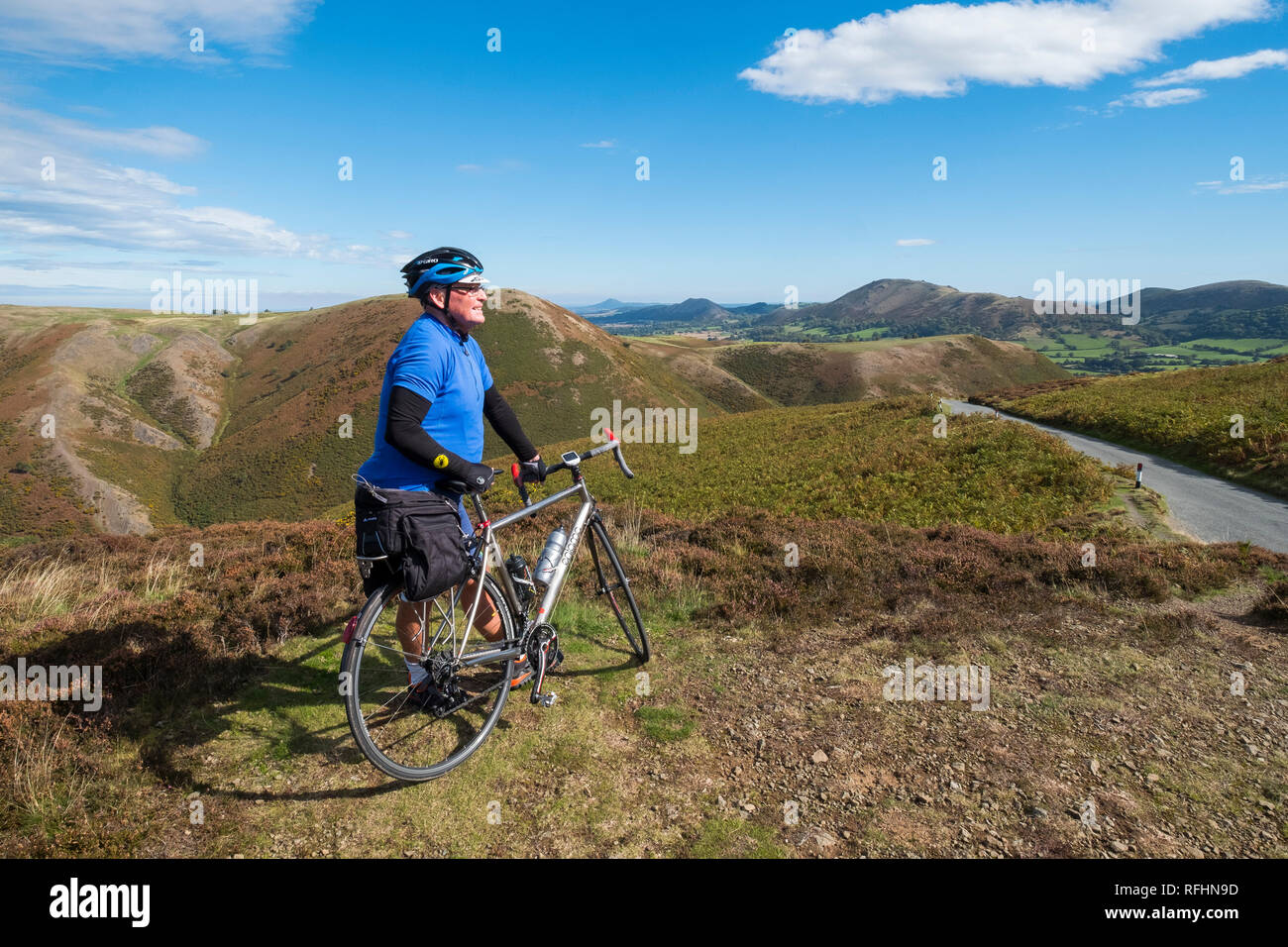 Eine männliche Radfahrer blickt auf den Shropshire Hills auf der Long Mynd in Church Stretton, Shropshire, England, Großbritannien Stockfoto