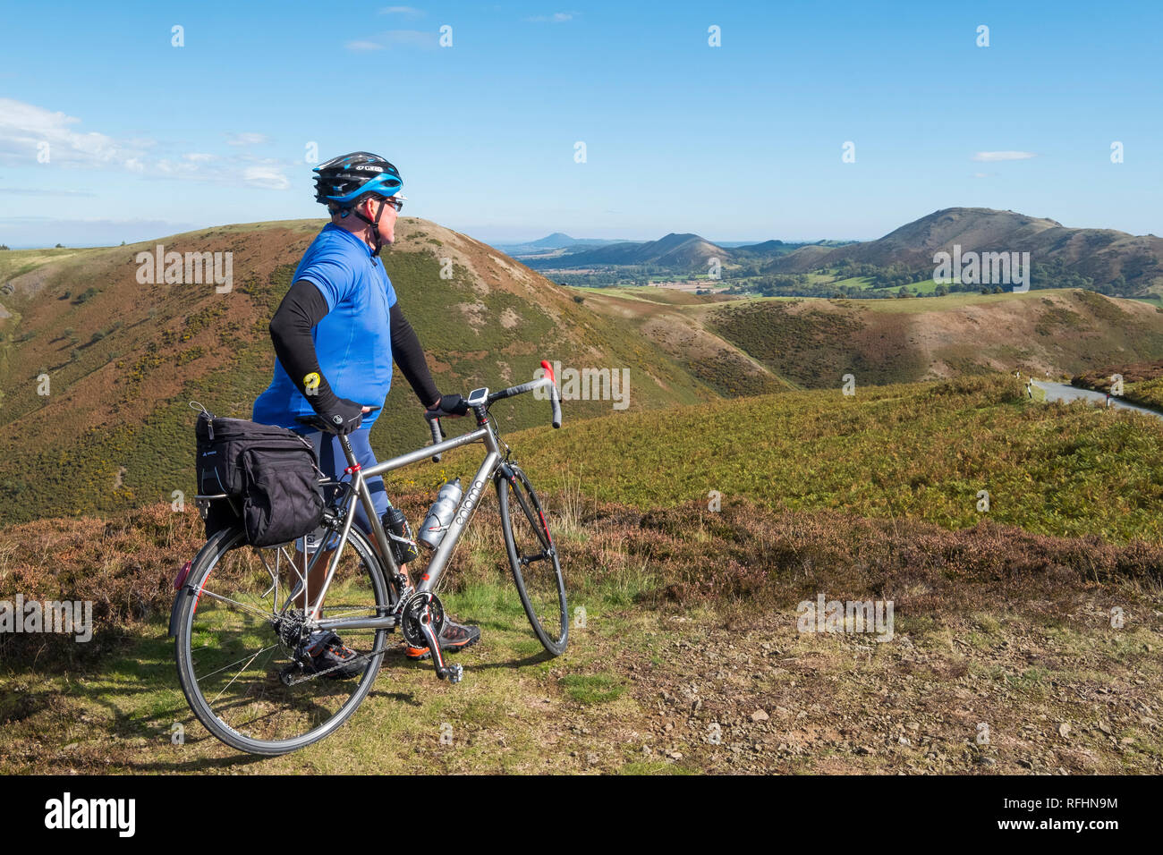 Eine männliche Radfahrer blickt auf den Shropshire Hills auf der Long Mynd in Church Stretton, Shropshire, England, Großbritannien Stockfoto