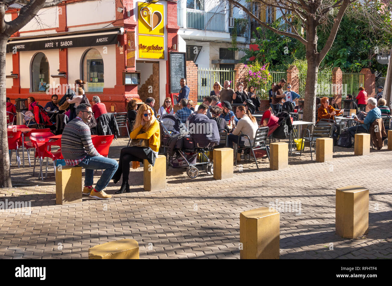 Kunden, die die Wintersonne vor der Tapas-Bar Arte y Solera in Sevilla, Spanien, genießen Stockfoto