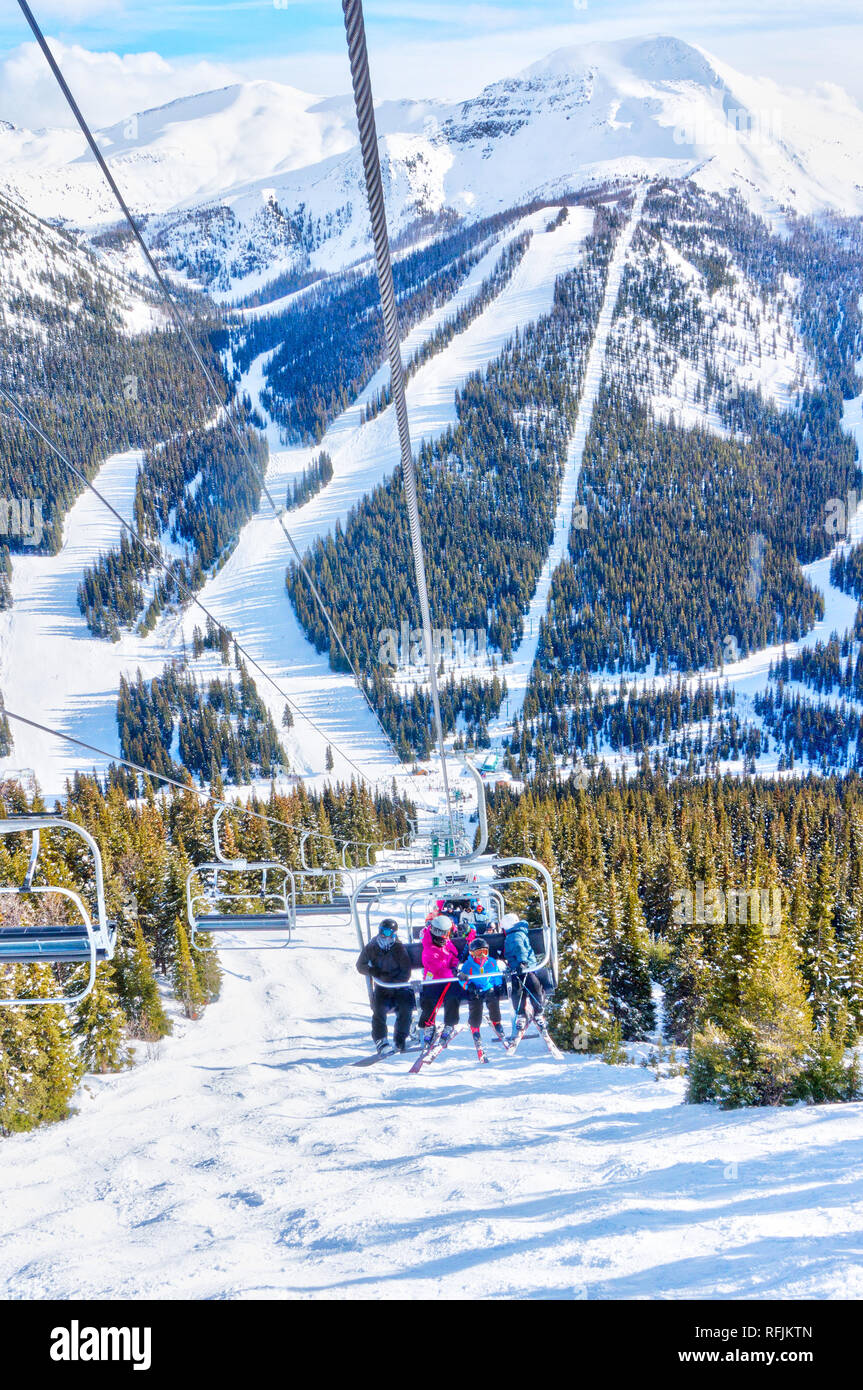 Nicht identifizierbare Skifahrer auf Sessellift auf einer Skipiste in die verschneite Bergwelt der Kanadischen Rockies. Stockfoto