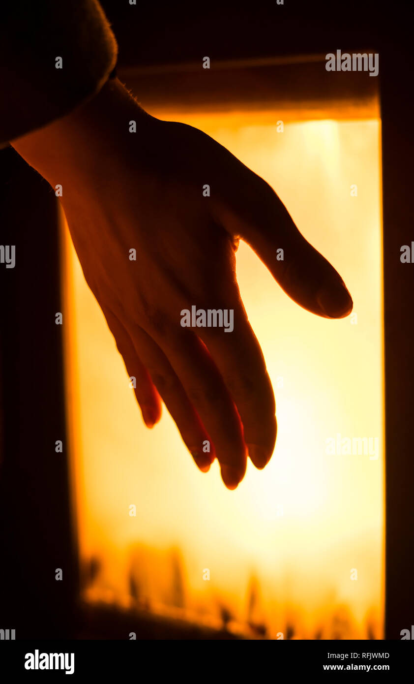 Mädchen ist Heizung Hand durch den Ofen zu hören. Stockfoto