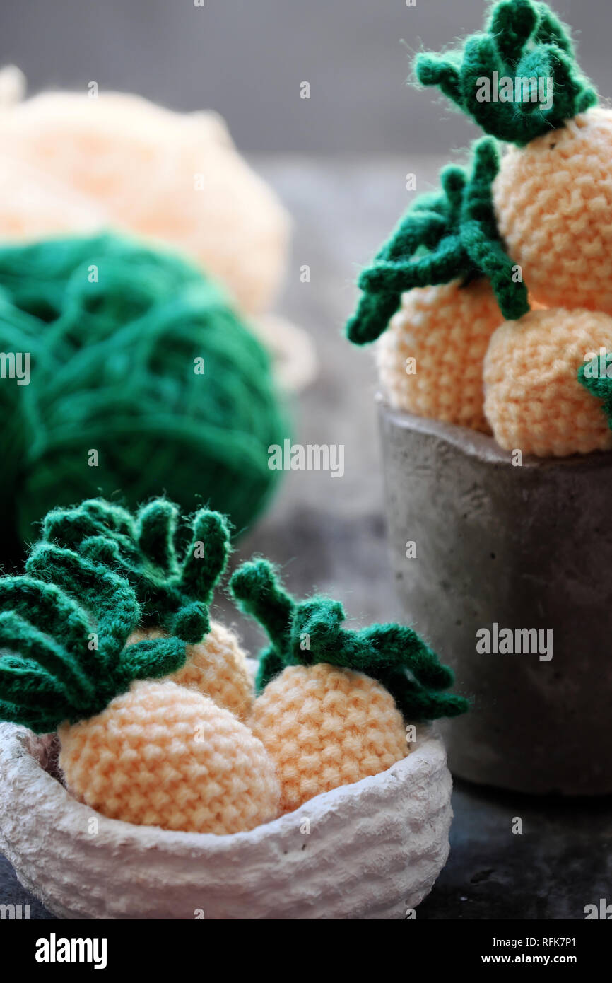 Handgefertigtes Produkt von auf grauem Hintergrund Holz stricken, Gruppe von Ananas Obst in Gelb mit grünen Blatt aus oder Kunst für Interior Design Stockfoto