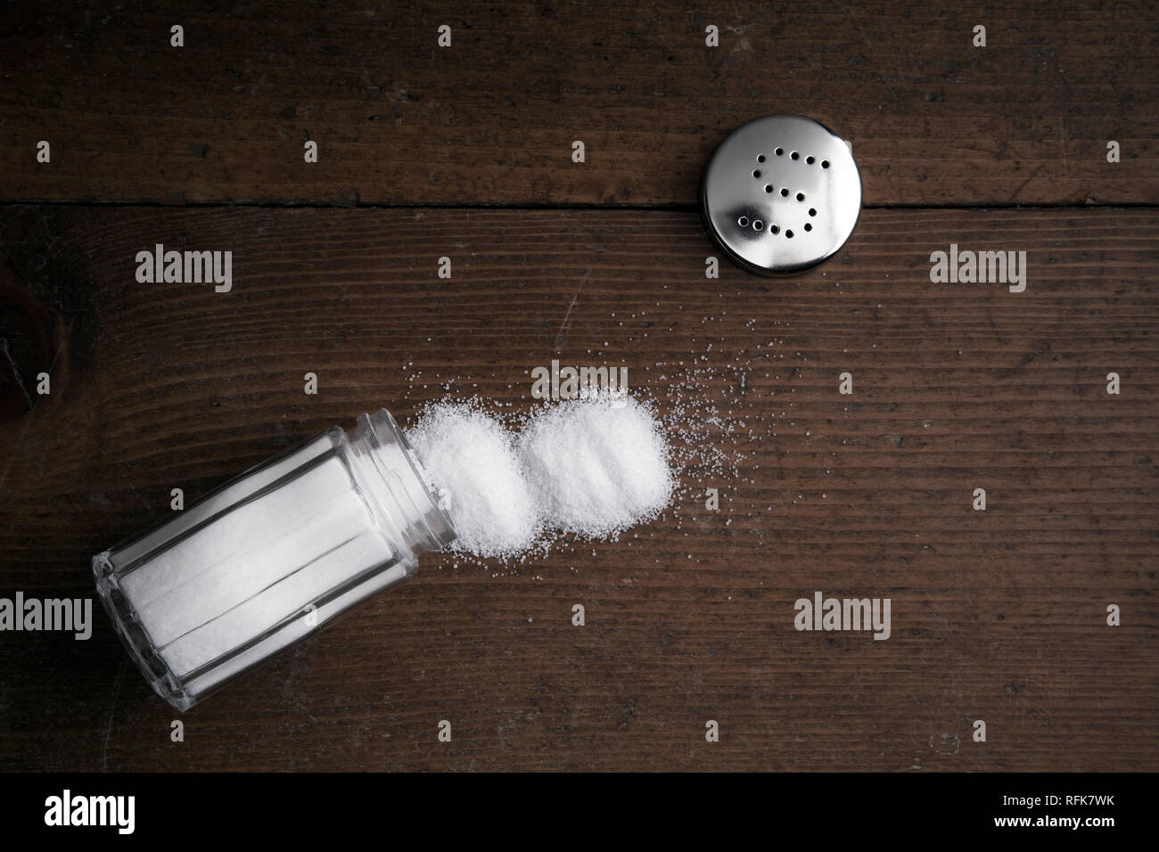 Umgeworfen Salt Shaker auf hölzernen Hintergrund Stockfoto