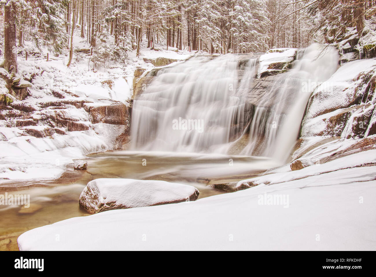 Kaskade Wasserfall auf Felsen. Winter Mumlava Fluß. Stürmische Bach im Wald in der Nähe. Stockfoto