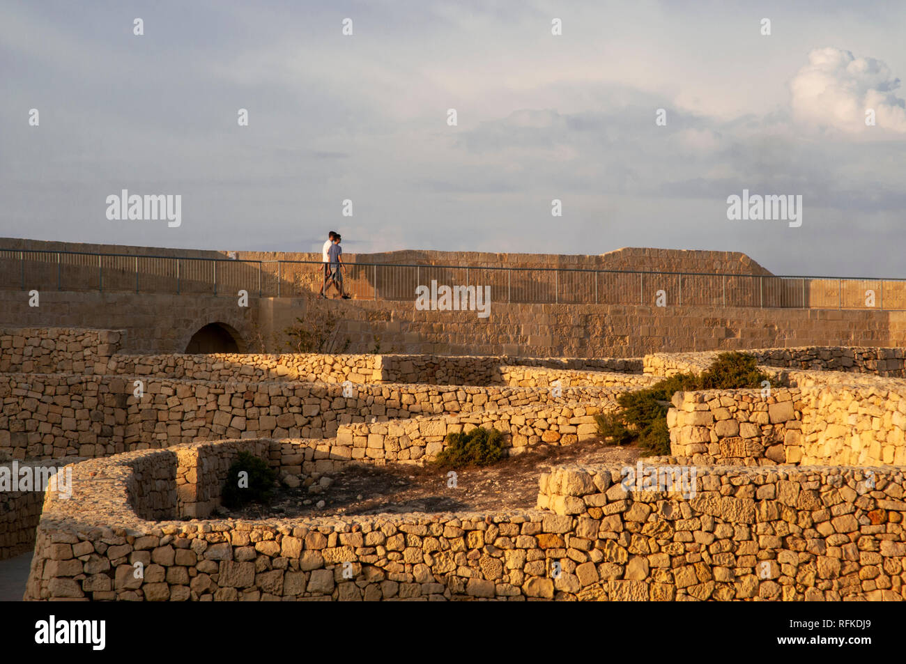 Zwei junge Männer zu Fuß entlang der nördlichen Stadtmauer der Zitadelle in Victoria, Gozo, Malta. Stockfoto