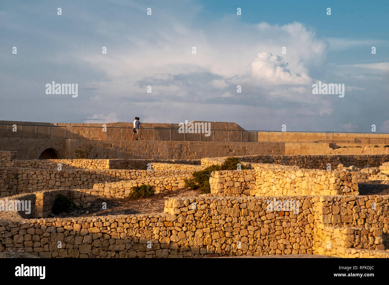 Zwei junge Männer zu Fuß entlang der nördlichen Stadtmauer der Zitadelle in Victoria, Gozo, Malta. Stockfoto