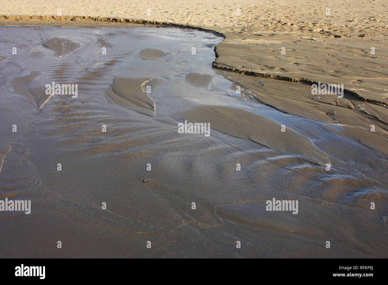 Strom von Wasser oder Verlust von Wasser am Strand des Meeres. torrent