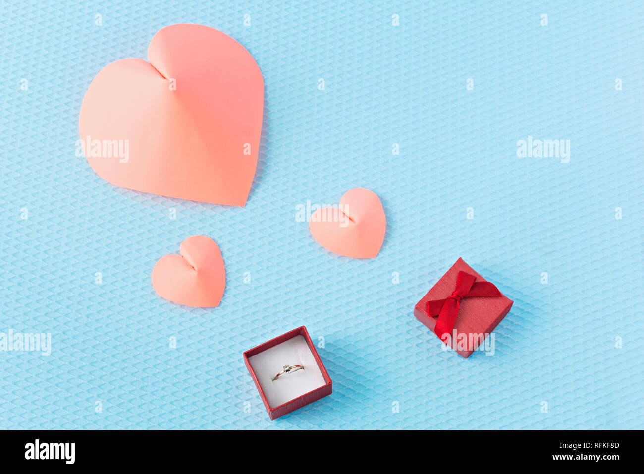 Herz und Ring auf einem blauen Hintergrund. Valentinstag. Valentinstag Grusskarten. Ein Angebot der Ehe. Engagement. Stockfoto