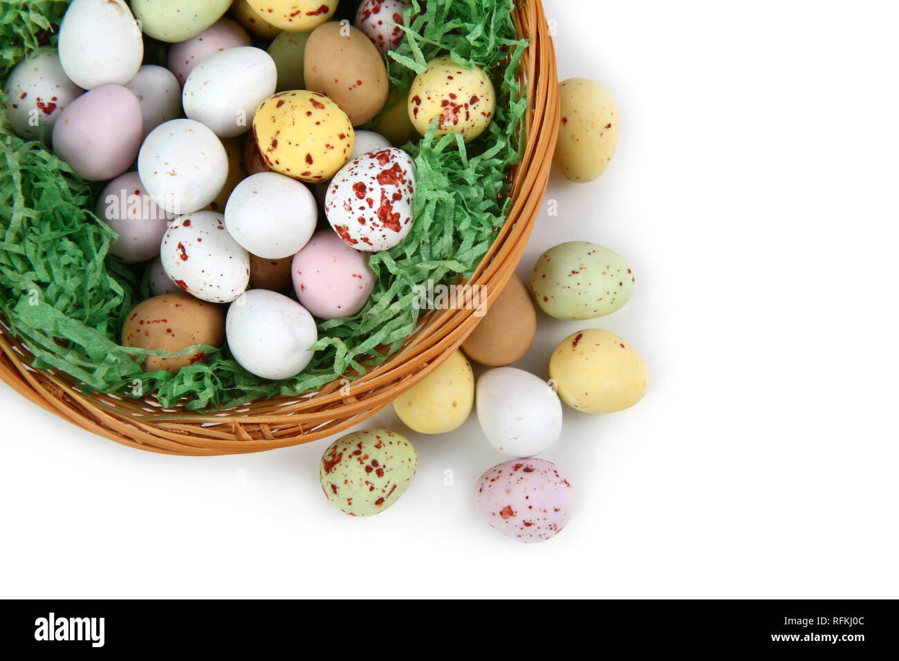 Schokolade mini Ostern Eier im Stroh oder whicker Korb vor einem weißen Hintergrund Stockfoto