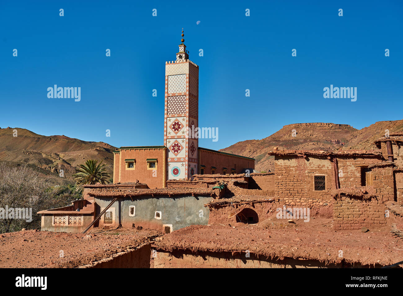 Traditionelle Dorfhäuser aus Lehmziegeln und farbenfroh dekoriertes Minarett/Moschee. In der Nähe von Tiseldei, Provinz Ouarzazate, Marokko Stockfoto