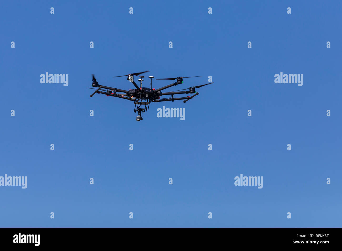 Unbemannte Luftfahrzeuge (UAV) oder Drohnen fliegen Silhouetten über dem blauen Himmel während der visuellen und thermischen Fotografie Inspektionen für die Industrie Stockfoto