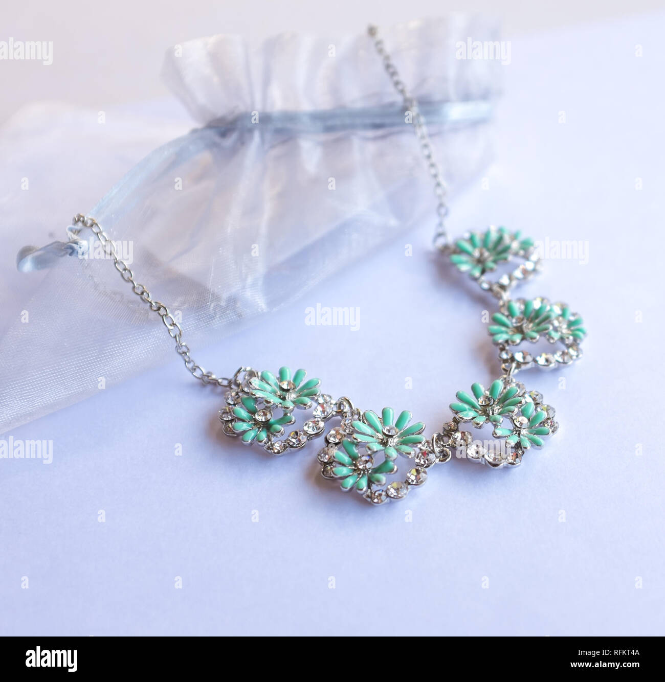 Silber Halskette mit grünen Blüten auf Weiß Stockfoto