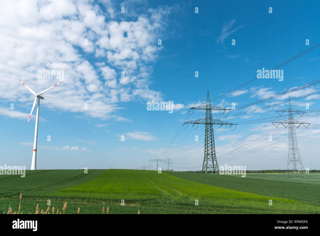 Stromleitungen und eine Windkraftanlage in ländlichen Deutschland gesehen Stockfoto