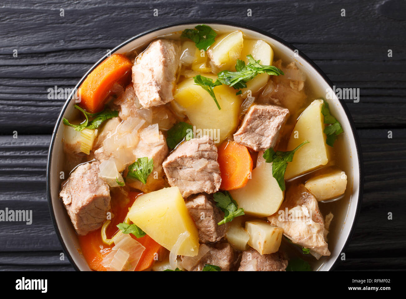 Deutsche Suppe oder Bismarck Pichelsteiner Eintopf mit Gemüse und drei Sorten Fleisch close-up in einer Schüssel auf den Tisch. Horizontal oben Ansicht von oben Stockfoto