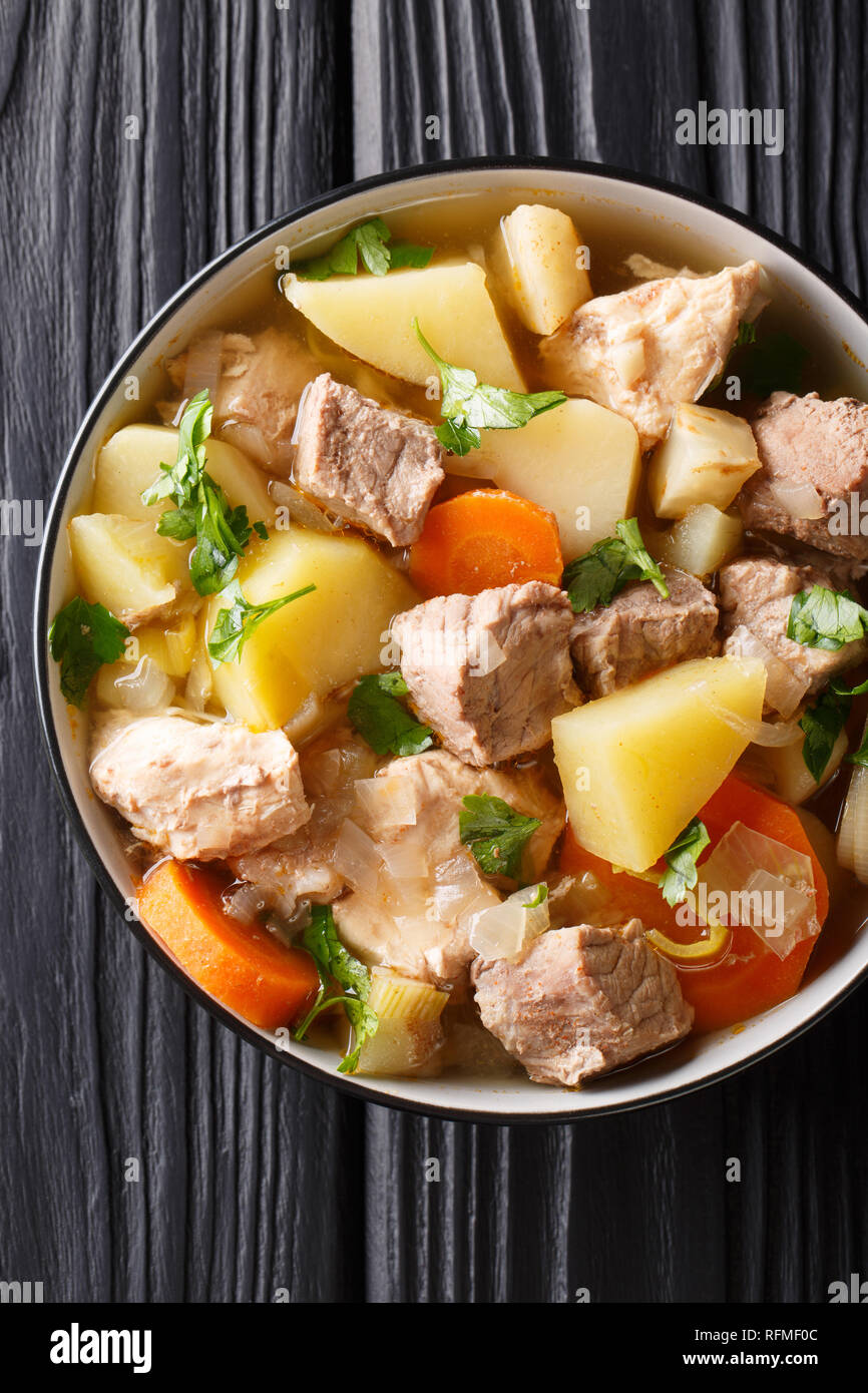 Deutsche Suppe oder Bismarck Pichelsteiner Eintopf mit Gemüse und drei Sorten Fleisch close-up in einer Schüssel auf den Tisch. Vertikal oben Ansicht von oben Stockfoto