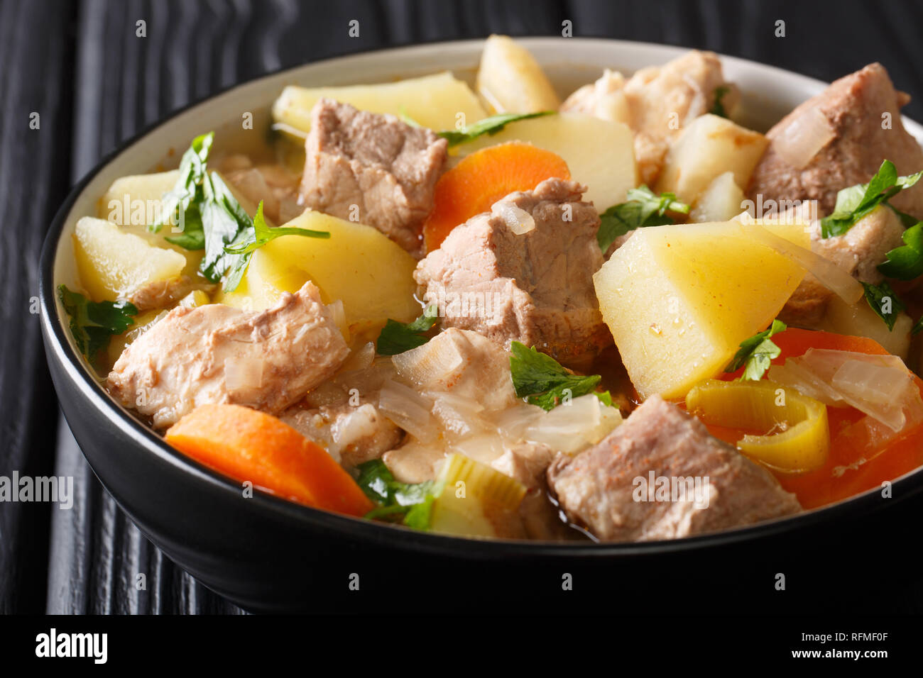 Deutsche Suppe oder Bismarck Pichelsteiner Eintopf mit Gemüse und drei Sorten Fleisch close-up in einer Schüssel auf dem Tisch. Horizontale Stockfoto
