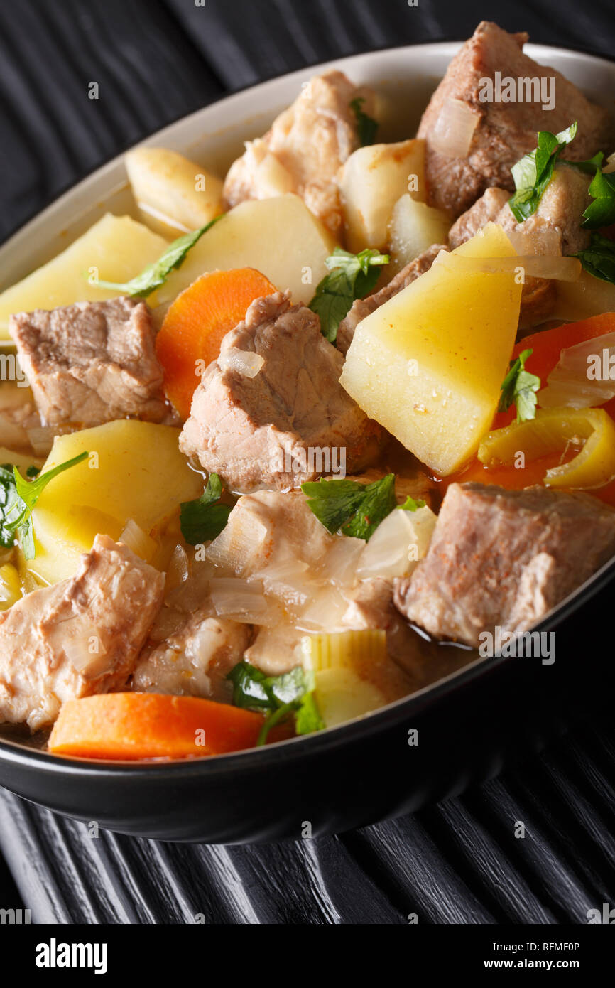 Dicke Deutsche Suppe Pichelsteiner mit Gemüse und drei Sorten Fleisch close-up in einer Schüssel auf dem Tisch. Vertikale Stockfoto