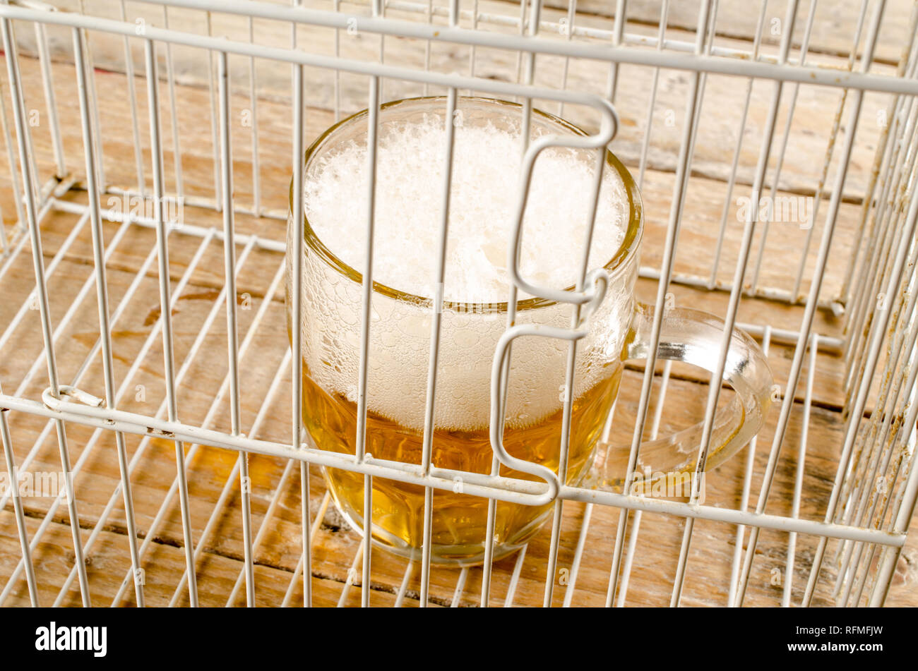 Glas Bier in einem Käfig, ein Konzept, das auf der Alkoholsucht und  Missbrauch Stockfotografie - Alamy