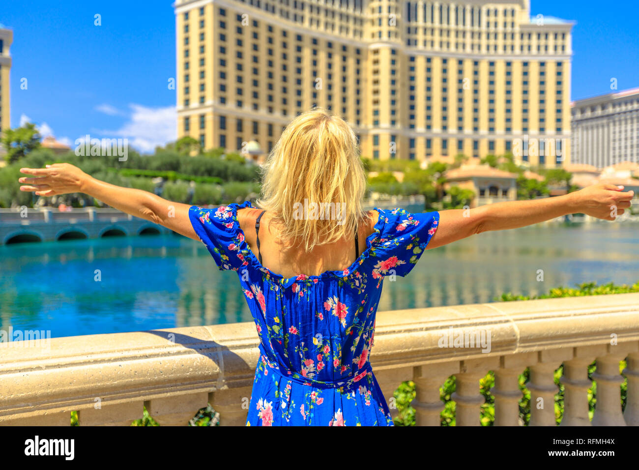 Kaukasische lifestyle Frau genießen am Teich mit klarem Wasser in Las Vegas Strip. Blond touristische Urlaub in Nevada, USA. Las Vegas Stadtbild tagsüber Stockfoto