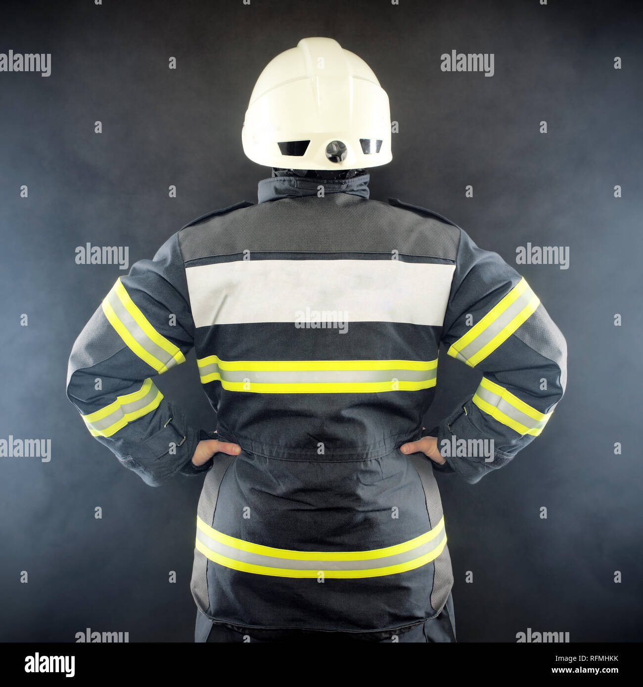 Rückansicht eines Feuerwehrmannes in Schutzanzug tragen Helm Stockfoto