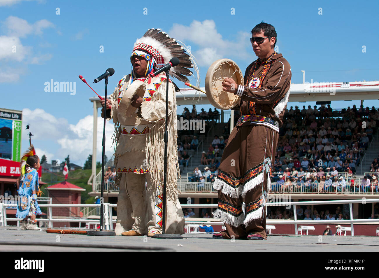 Canadian native in traditioneller Kleidung singen und spielen die typischen in Calgary Stampede Show, Calgary, Alberta, Kanada drum Stockfoto