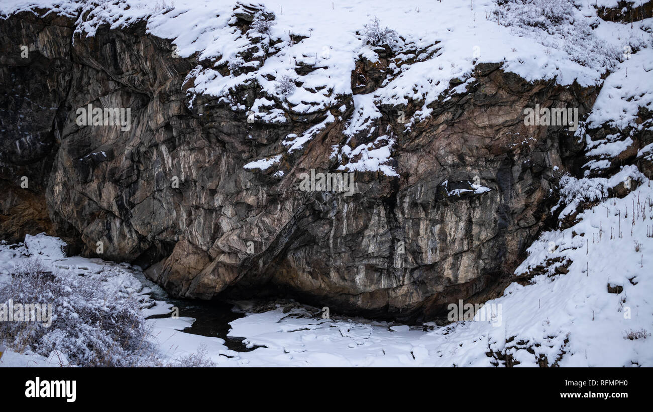 Schnee bedeckte Felswand mit teilweise gefroren Clear Creek unten, Januar 12,2019 Clear Creek Canyon Colorado, USA Stockfoto