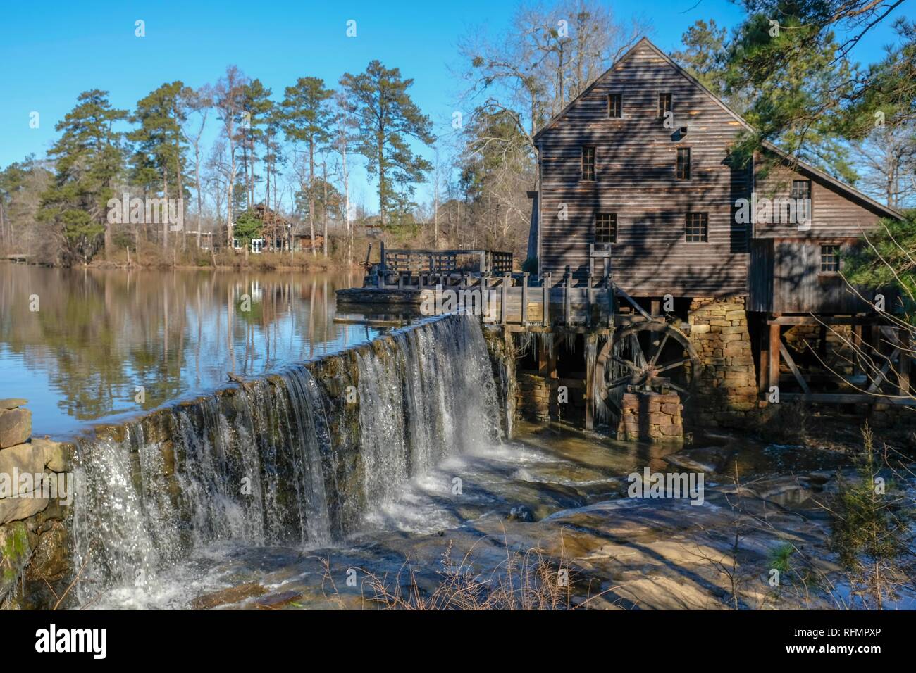 Malerische Winter Blick auf den Wasserfall und den Damm durch die alte Mühle an der historischen Mühle Yates County Park in Raleigh, North Carolina. Eiszapfen Hand aus der f Stockfoto