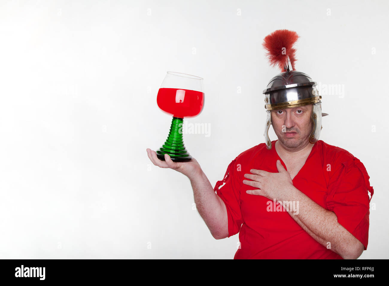 Ein römischer Soldat betrunken mit einem Glas Wein auf dem weißen Hintergrund. Stockfoto