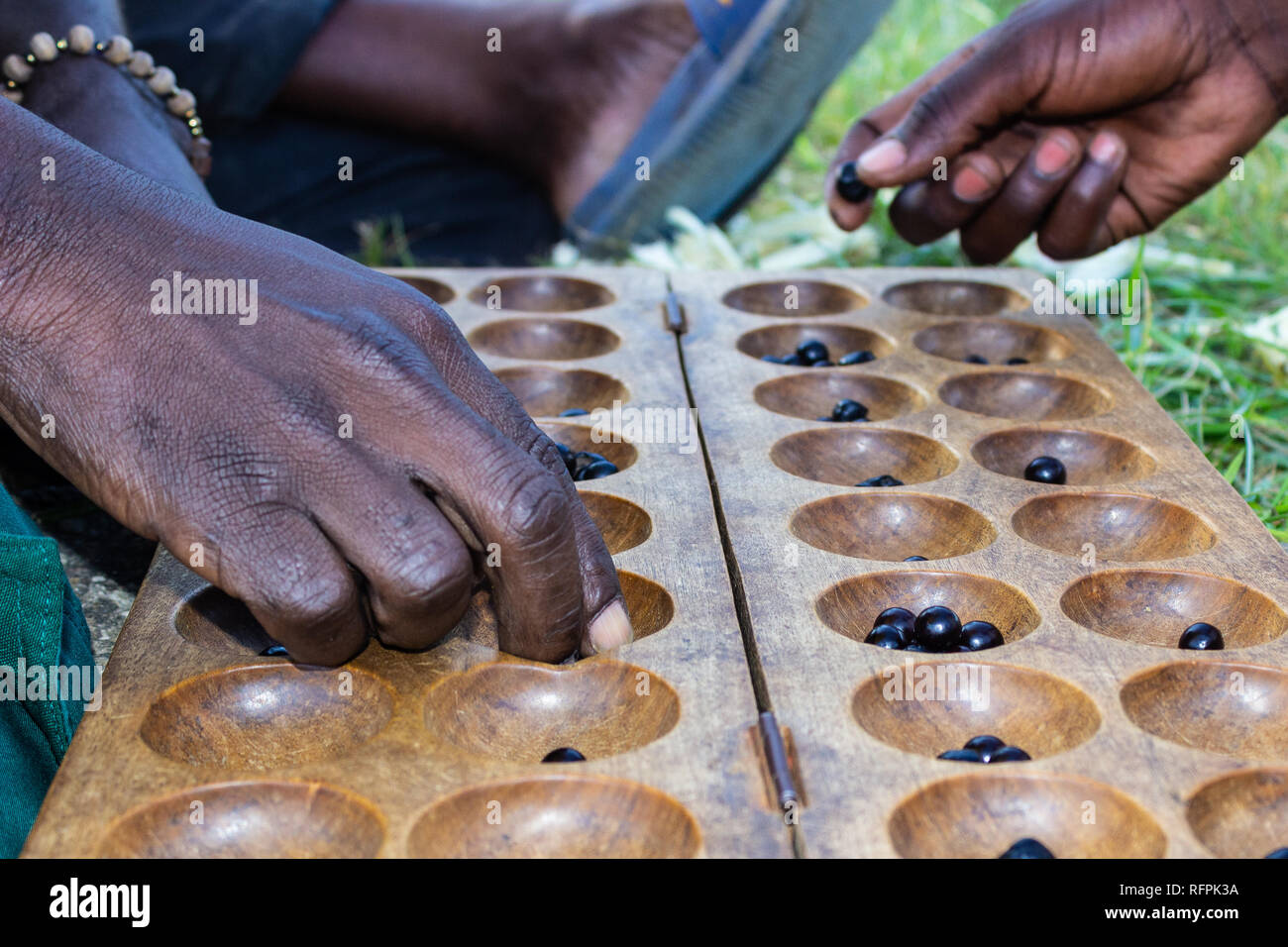 Zwei Männer spielen ein Brettspiel namens Igisoro, in Ruanda, Ostafrika Stockfoto