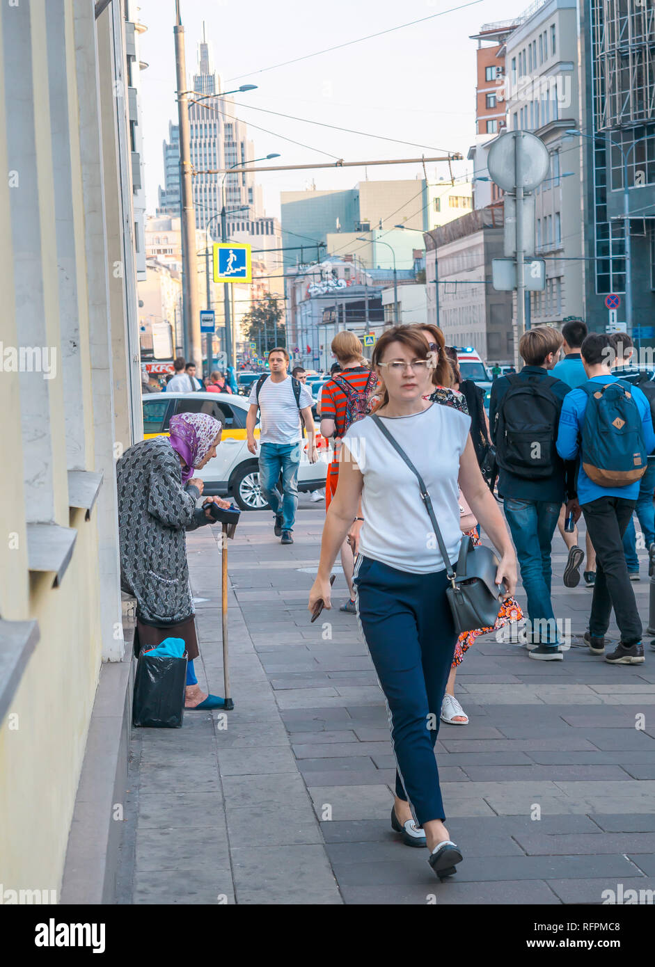 Moskau, Russland - September 6, 2018: Ältere Frau bittet um Almosen von Passanten auf der Straße. Rentner ständigen beugte sich mit einem Stock Kreuz selbst und Stockfoto