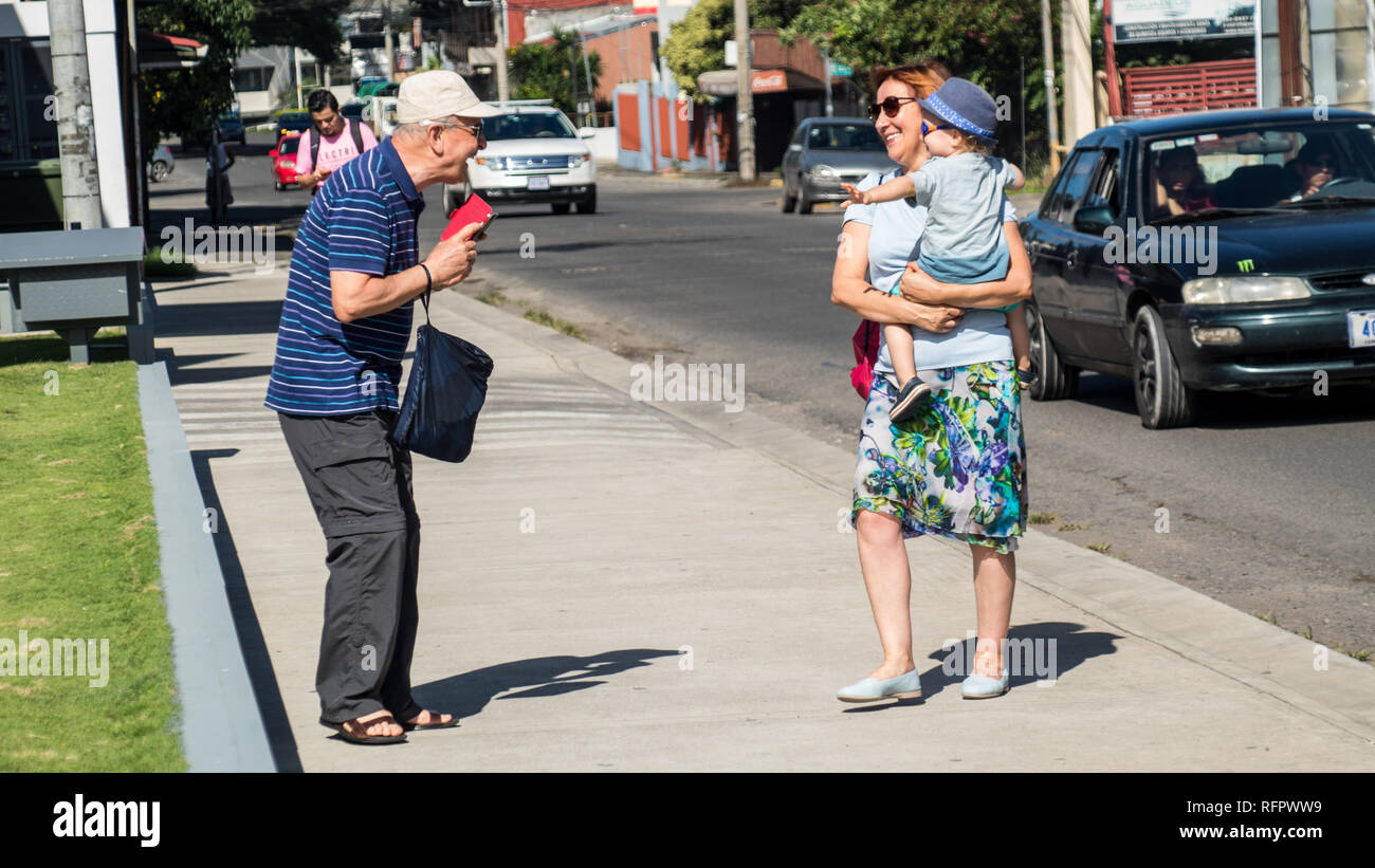 Ein Foto von einem Großvater lächelnd Ant Fotos von seiner Frau und ihren Enkel. Alle lachen und Spaß haben. Santa Ana, Costa Rica. Stockfoto