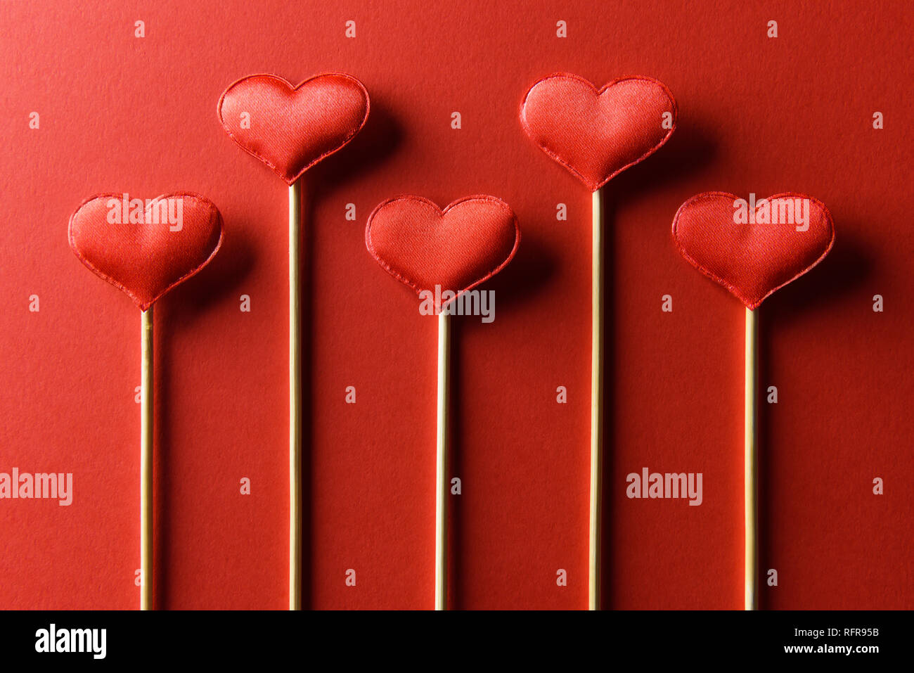 Red textile Herzen auf Holzstäbchen Nahaufnahme. Valentines Tag Hintergrund, kreative Textur und liebe Konzept Stockfoto