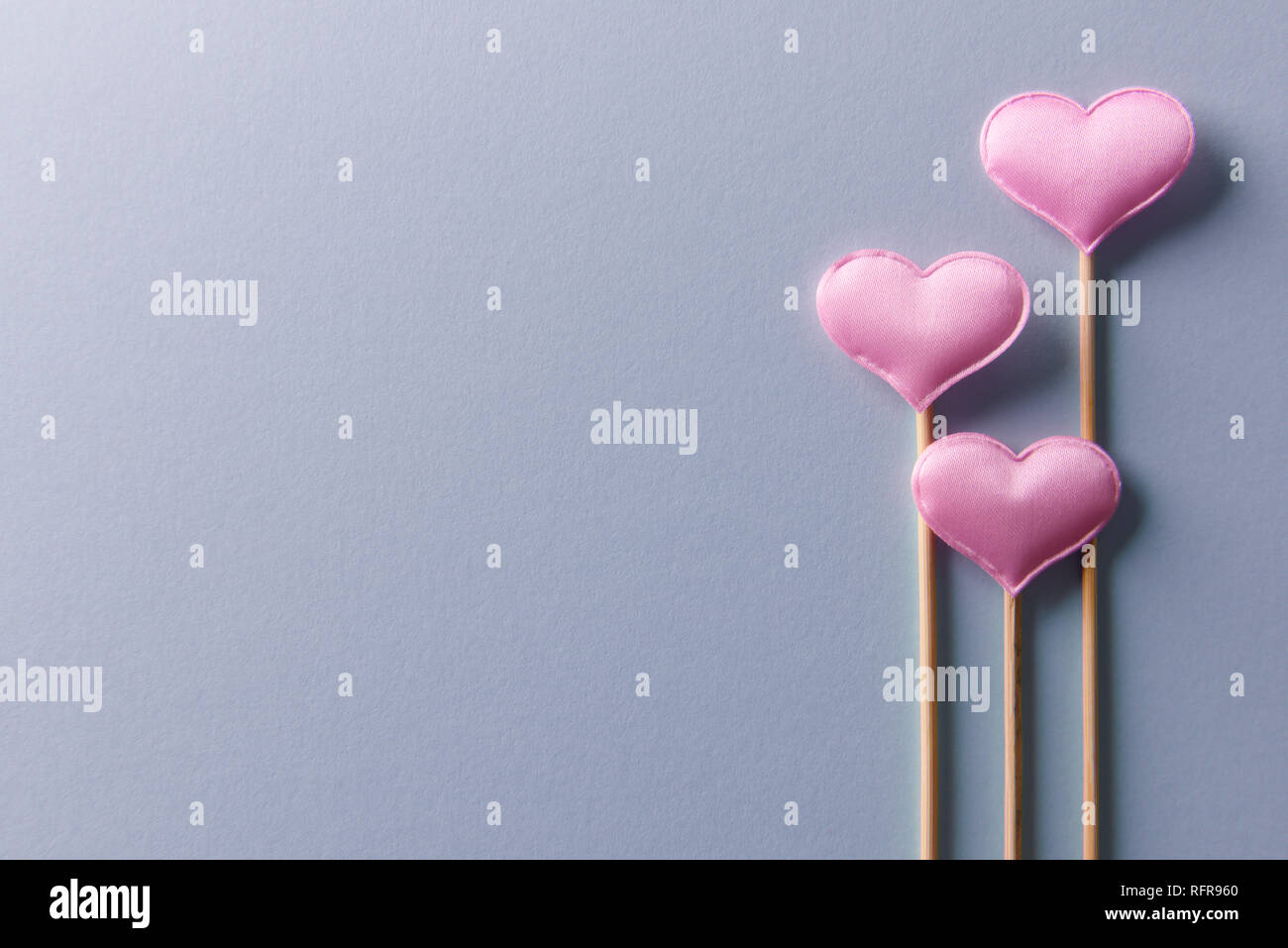 Rosa textile Herzen auf Holzstäbchen Nahaufnahme. Valentines Tag Hintergrund, kreative Textur und liebe Konzept Stockfoto