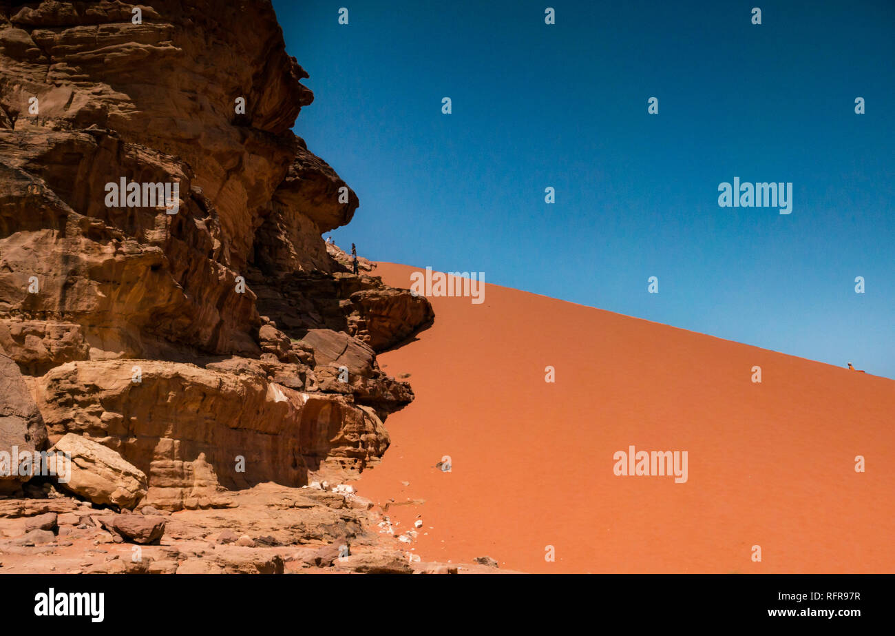 Riesige Sanddüne mit Leute an der Spitze der Skala, Wadi Rum wüste Tal, Jordanien, Naher Osten Stockfoto