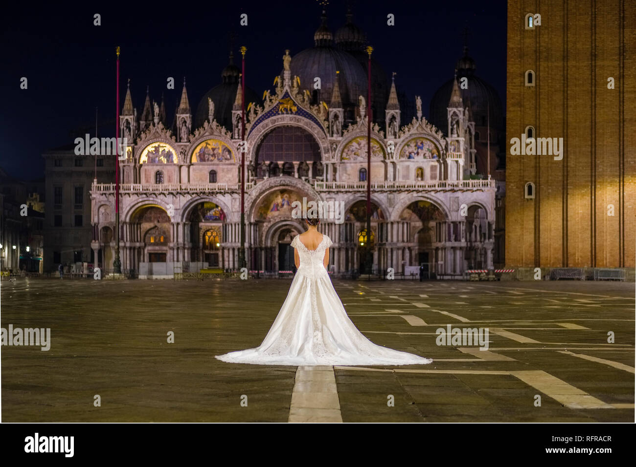 Eine Braut, die in einer Hochzeit Kleid steht auf dem San Marco Platz, Piazza San Marco, bei Nacht Stockfoto